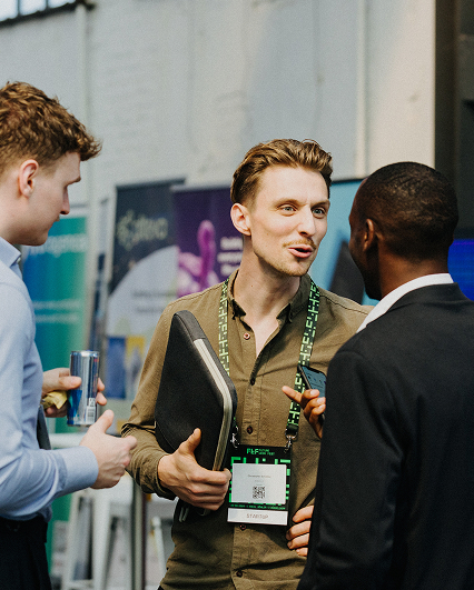 Drei Männer im Gespräch beim Networking-Event.